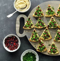 a platter filled with christmas tree shaped crackers next to bowls of dips