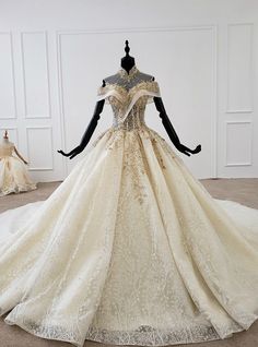 a wedding dress is displayed on a mannequin in front of a white wall