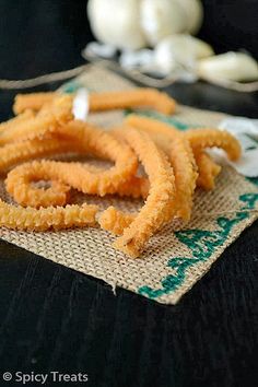 some onion rings are sitting on top of a cloth next to garlic cloves