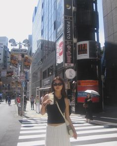 a woman standing in the middle of a cross walk