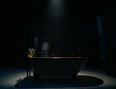 a bathtub in the middle of a dark room with a light shining on it