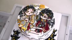 the cake is decorated with two girls on it's side and has black cats around them