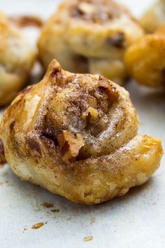 cinnamon rolls are sitting on a white surface