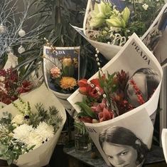 a bunch of flowers sitting on top of a table next to a vase filled with flowers