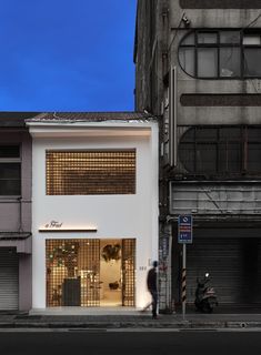 an empty street in front of two tall buildings with shutters on the doors and windows