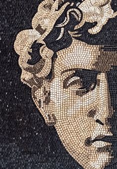 a close up of a mosaic on the side of a building with a woman's face