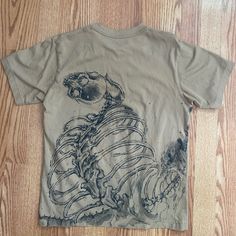 Uniqlo X Attack On Titan Collab Shirt In Tan Limited Edition ! Insane Graphic Designs Size Xs Measurements: Length (From Highest Point Of Shoulders To Hem): 23.5in Chest: 17.5in Sleeve Opening: 6.25in No Flaws, No Stains, Like Brand New All Items Are Washed Beforehand Feel Free To Ask Any Questions :) Star Wars Bleach Shirts, Grunge Style Printed Short Sleeve Tops, Grunge Short Sleeve Printed Tops, Casual Cotton T-shirt With Skull Print, Fitted Short Sleeve Shirt With Skull Print, Casual Fitted Skull Print Tops, Casual Fitted Tops With Skull Print, Printed Cotton Grunge T-shirt, Fitted Casual Tops With Skull Print