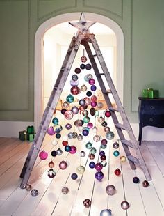 a christmas tree made out of wooden ladders with ornaments hanging from the top and bottom