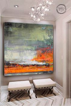 a large painting hanging on the wall above two stools