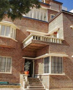 a large brick building with stairs leading up to the front door and second story windows