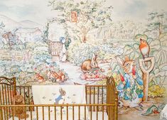 a baby crib in front of a wall mural