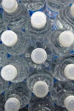 many empty water bottles are stacked together