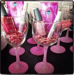 two wine glasses filled with pink glitter and nail polish