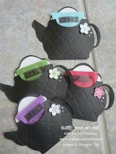 three black teapots with sunglasses and flowers on them