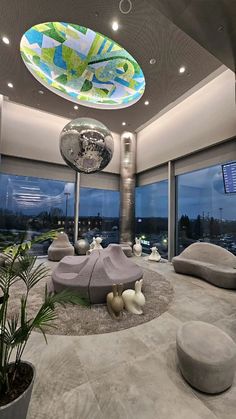 a modern living room with large windows and an artistic ceiling light above the couches