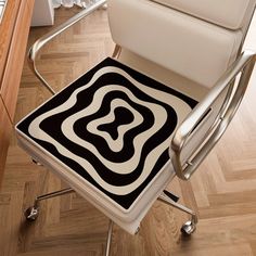 a chair with a black and white rug sitting on top of it next to a computer desk