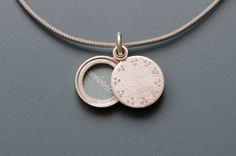 This small locket for one picture is handmade in solid sterling silver. The  secret locket only reveals the treasure inside, when you slide the lid to the side. But you can also keep it hidden and just show the minimalist dot pattern, that decorates the lid of the pendant. Locket for one picture - diameter 14mm (0,55")- thickness: ca. 3mm (0,13") - design: little dots  - Sterling Silver How it works: * The lockets consist of two movable parts, fitting tightly together. * You have to push the lid Silver Minimalist Locket Necklace For Everyday, Silver Minimalist Locket Necklace Gift, Silver Minimalist Locket Necklace As Gift, Silver Minimalist Locket Necklace For Gift, Everyday Sterling Silver Locket Necklace, Minimalist Sterling Silver Locket Pendant Necklace, Minimalist Sterling Silver Locket Necklace, Minimalist Sterling Silver Locket Necklace Gift, Minimalist Silver Locket Necklace With Round Pendant