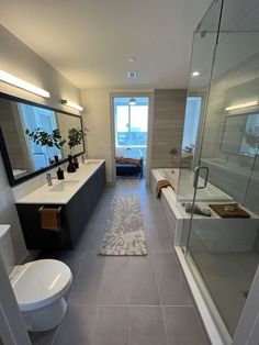 a large bathroom with a walk in shower next to a white toilet and bathtub