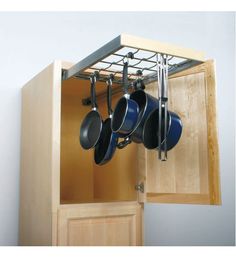 pots and pans are hanging from the cabinet