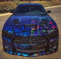 the front end of a blue sports car with holographics on it's hood