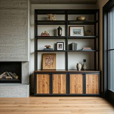 a living room filled with furniture and a fire place in the middle of it on top of a hard wood floor