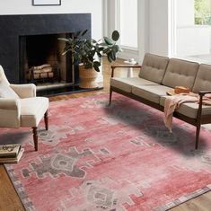 a living room filled with furniture and a rug on top of a hard wood floor