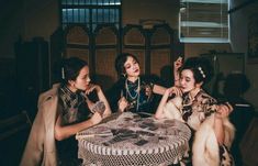 three young women sitting around a table together