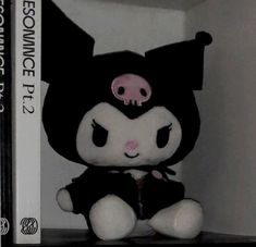 a black and white stuffed animal sitting on top of a shelf