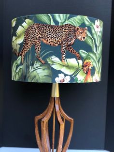 a lamp with a cheetah and jungle print shade on it's side