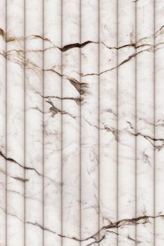 a white marble wall with vertical lines in the center and diagonals on it's sides