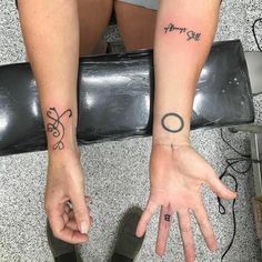 two people with tattoos on their hands and one has the word love written on it