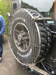 a man standing next to a large tire fan