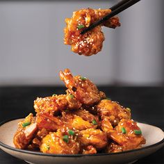 a bowl full of food with chopsticks sticking out of the meat in it