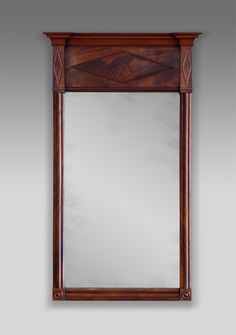 a wooden mirror hanging on the wall