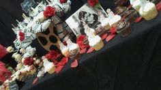 a table topped with pictures and cakes covered in frosting on top of a black cloth