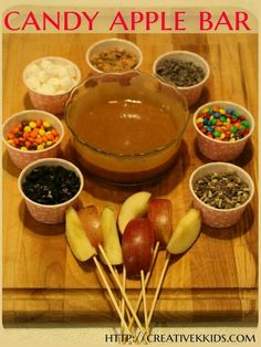 candy apple bar with apples, marshmallows and candies in small bowls