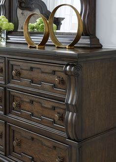 an ornate dresser with two circular mirrors on top