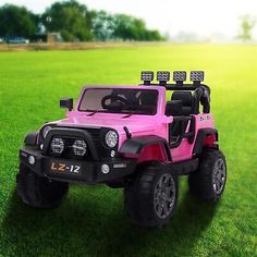 a pink toy jeep is parked in the grass