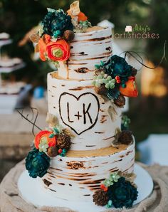 the wedding cake is decorated with flowers and leaves