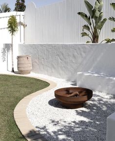 a wooden table sitting on top of a gravel covered ground next to a white fence