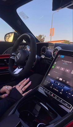 a woman is sitting in her car with the steering wheel and touch screen on display