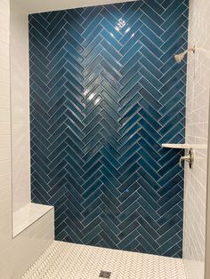 a bathroom with blue and white tiles on the wall, shower head in the corner