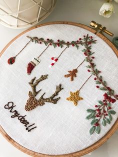 a cross stitch christmas ornament on a wooden hoop