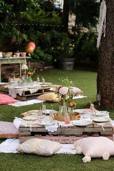 an outdoor picnic is set up in the grass