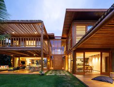 an outdoor living room and dining area are lit up at night