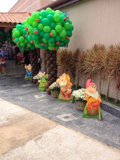 some balloons are in the shape of trees and gnomes on the side of a building