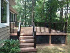 a deck with railings and steps leading up to the house