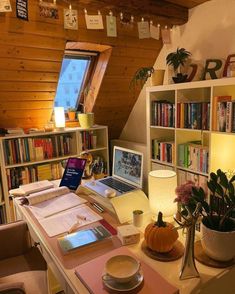 a laptop computer sitting on top of a desk in front of a book shelf filled with books