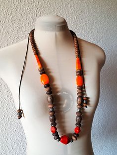 This statement, massive necklace has large stones in red and orange and wood beads of different size. A large diamand shape large stone sits at the bottom which adds boldness. It is hand strung and tied with ties. This necklace in excellent used condition. Measuriments: total length - 168 cm/ 66'' with ties size large stone beads - 4cm/1.6'' and 3 cm/ 1.2'' Unique Orange Necklace With Wooden Beads, Unique Orange Necklace With Large Beads, Orange Wooden Beads Jewelry For Festival, Unique Orange Jewelry With Wooden Beads, Bohemian Orange Necklaces With Wooden Beads, Bohemian Orange Necklace With Wooden Beads, Orange Large Beaded Necklace For Festivals, Festival Orange Large Beaded Necklaces, Festival Orange Large Beads Necklace