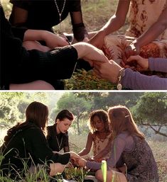 four women sitting in the grass and one is holding her hand out to another woman